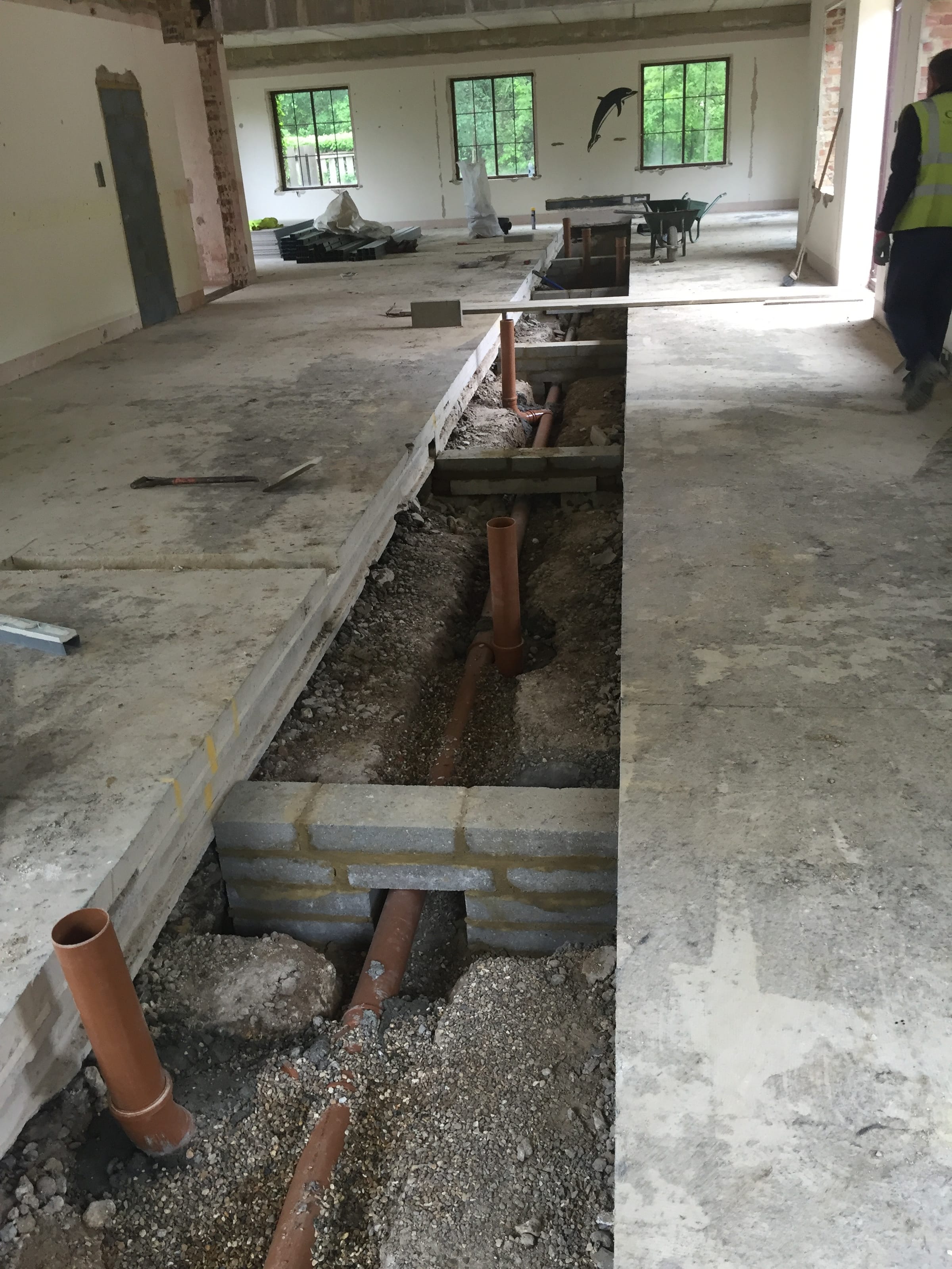 Drainage pipework being installed in a barn conversion floor