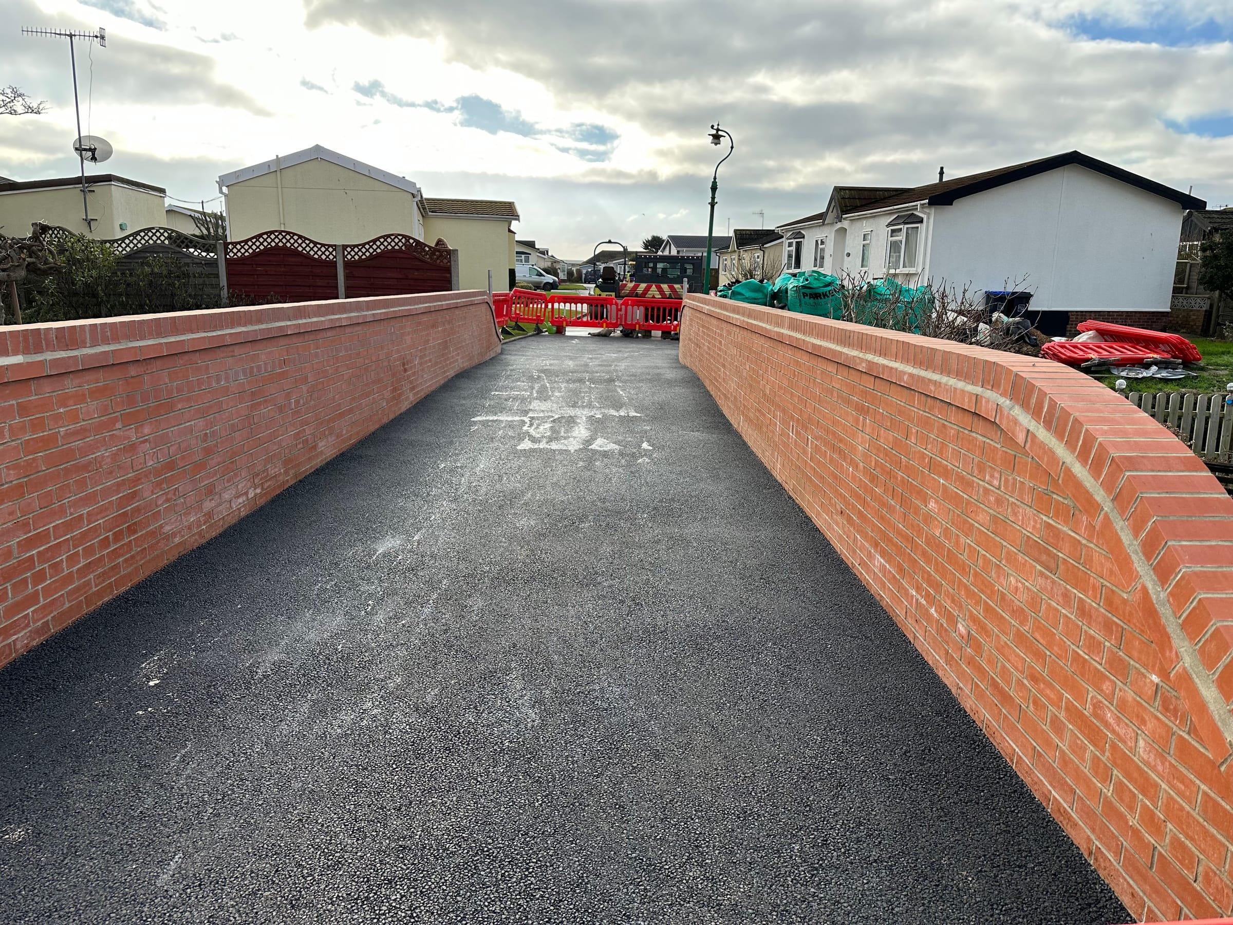 Finished tarmac footbridge with brick parapet walls
