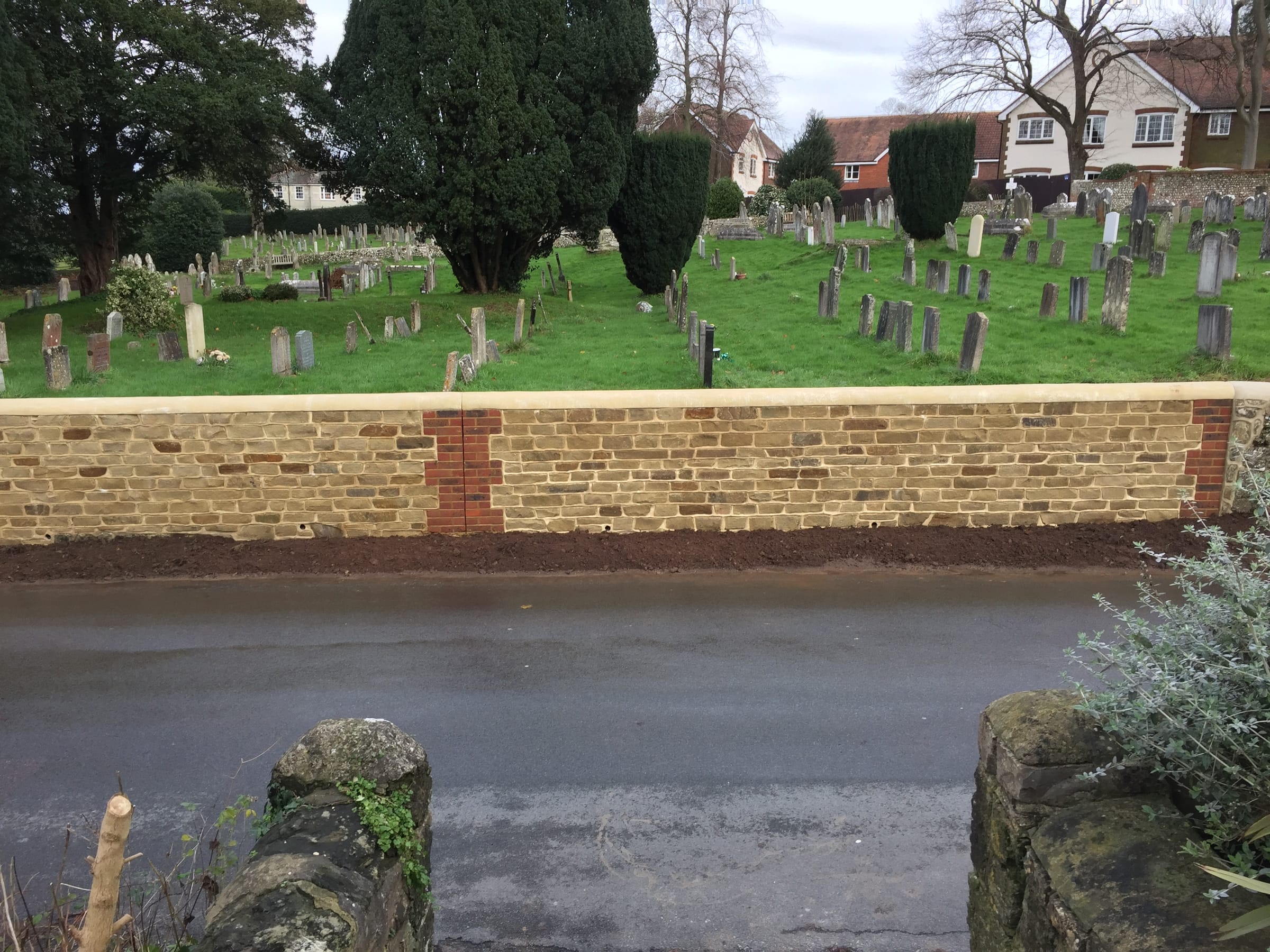 Natural stone boundary wall alongside a churchyard