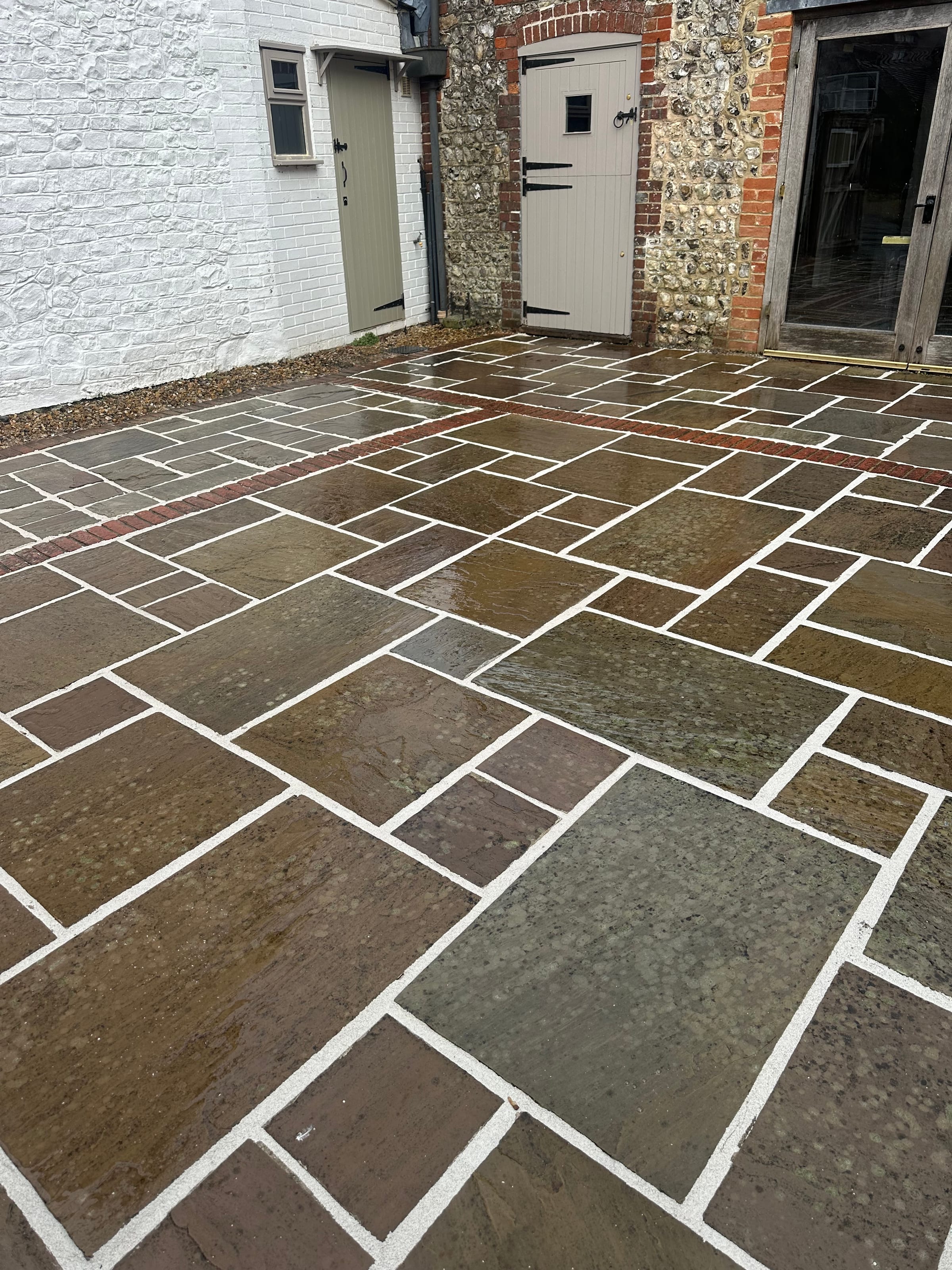 Riven natural stone courtyard patio with brick banding