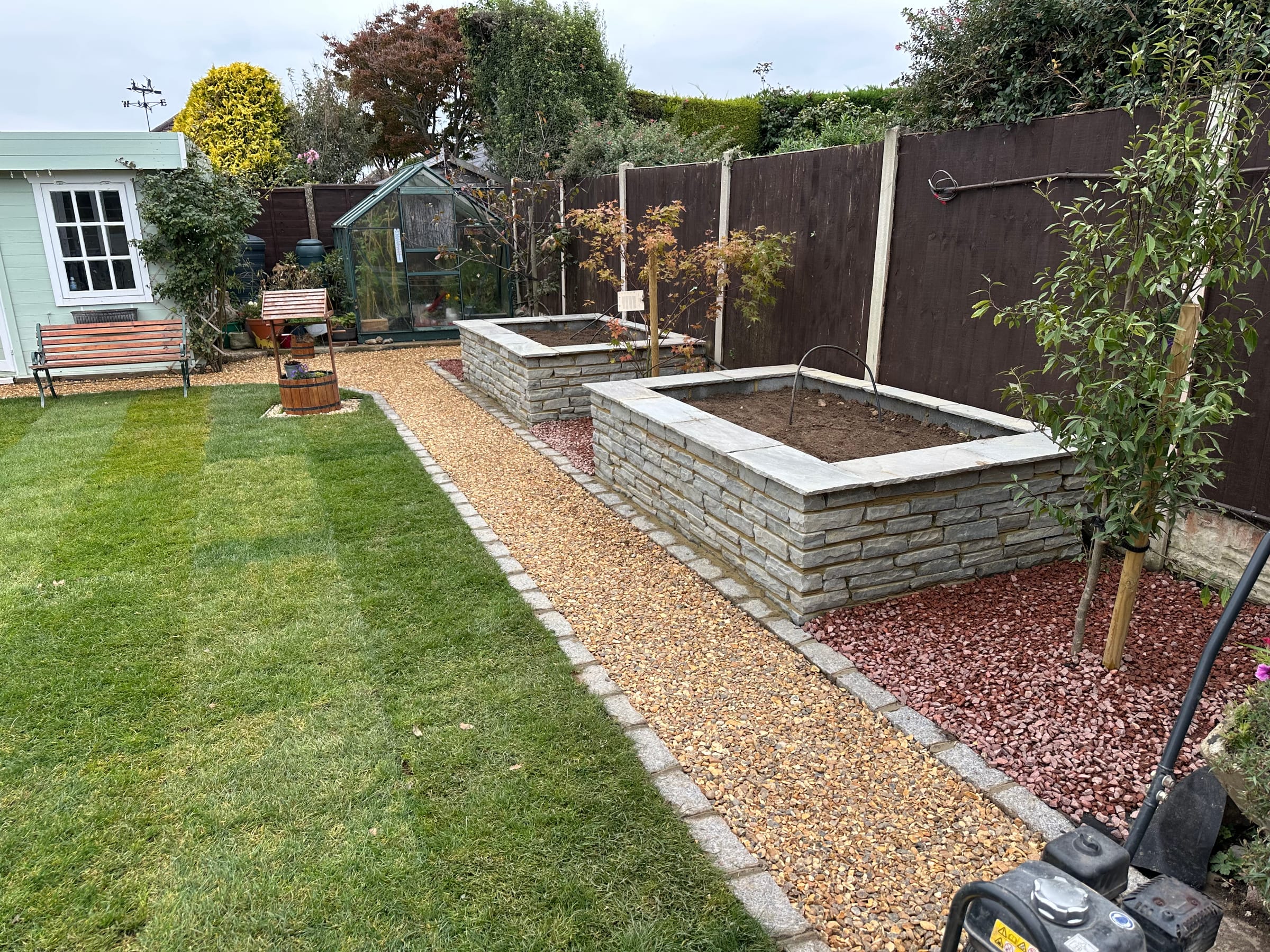 Finished garden landscaping with lawn and raised stone beds