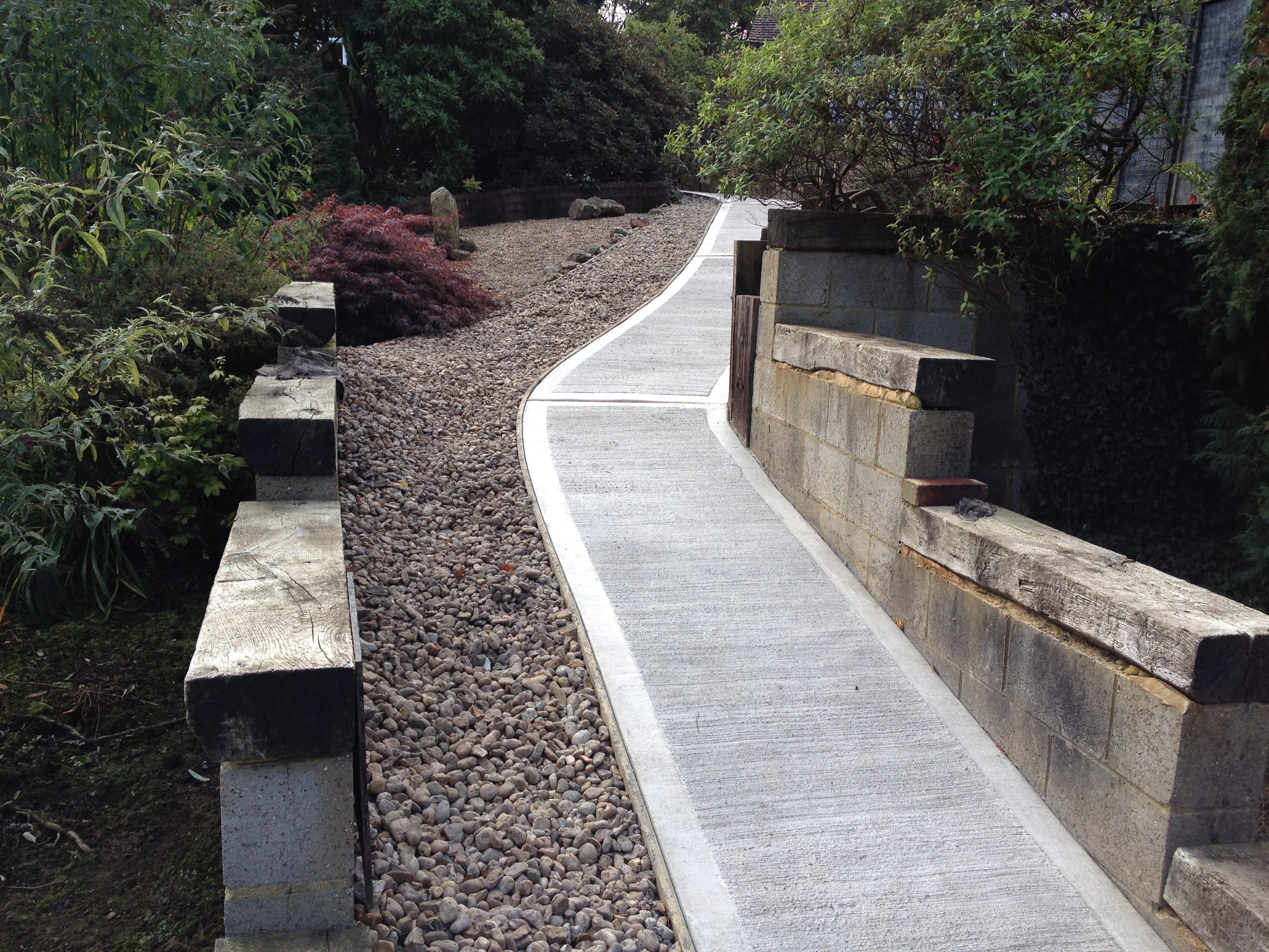 Curved concrete garden path with gravel border