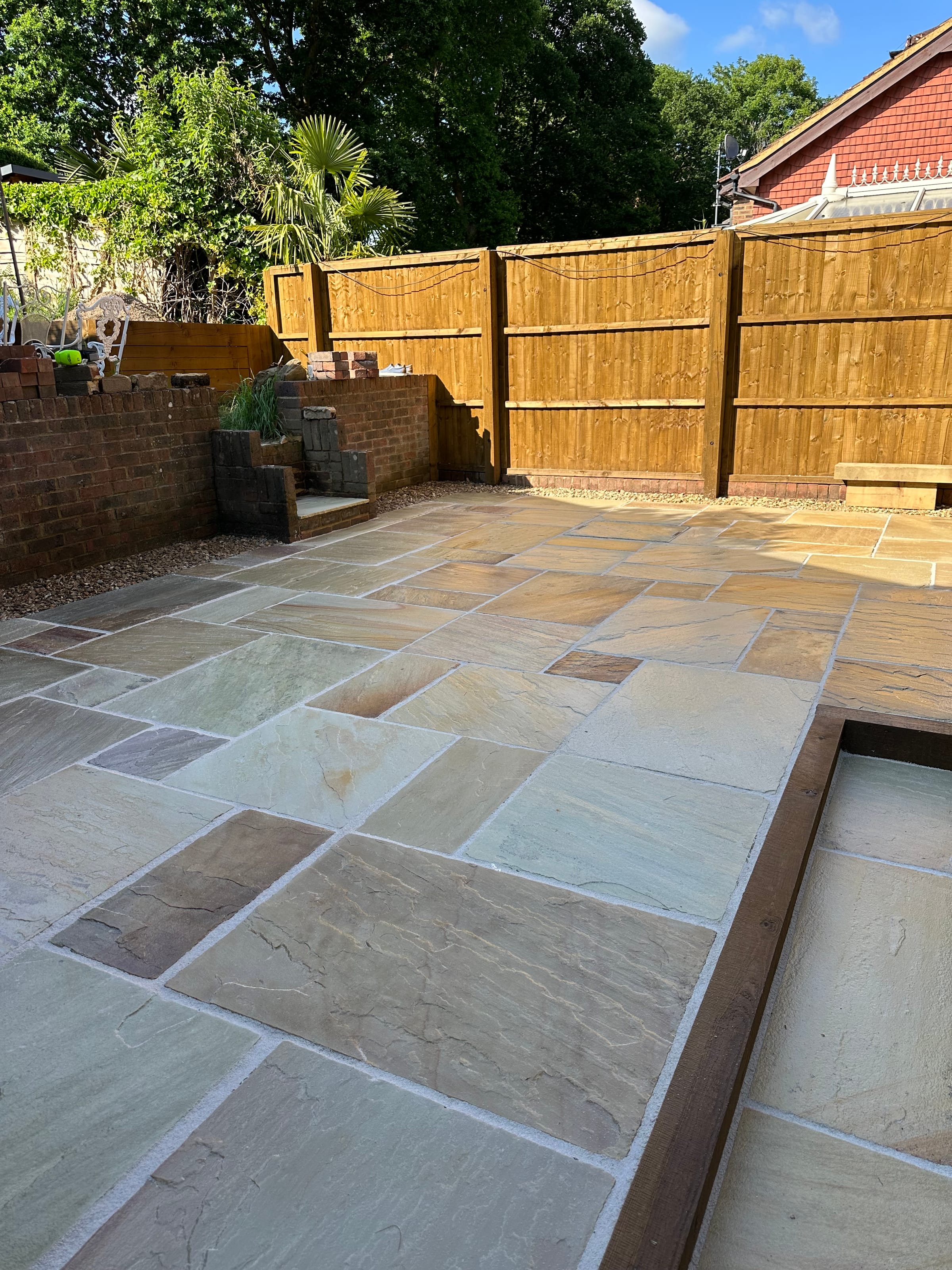 Indian stone patio with new timber fencing and raised beds
